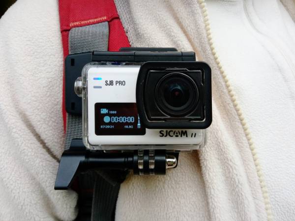The SJCAM SJ8 Pro mounted on the shoulder strap of a backpack
